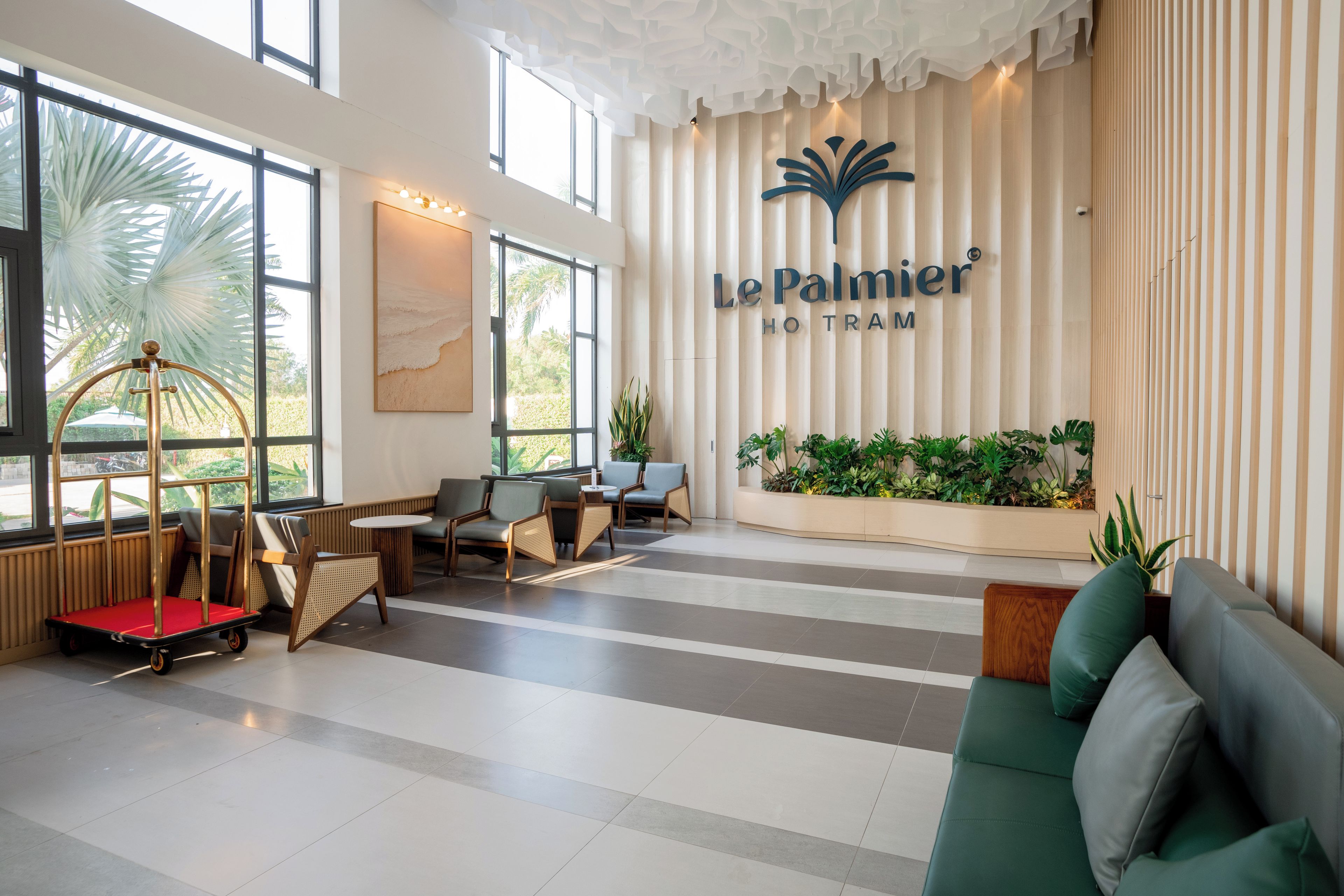 En hotellobby med en receptionsdisk, en sittgrupp och en vägg med hotellets namn.