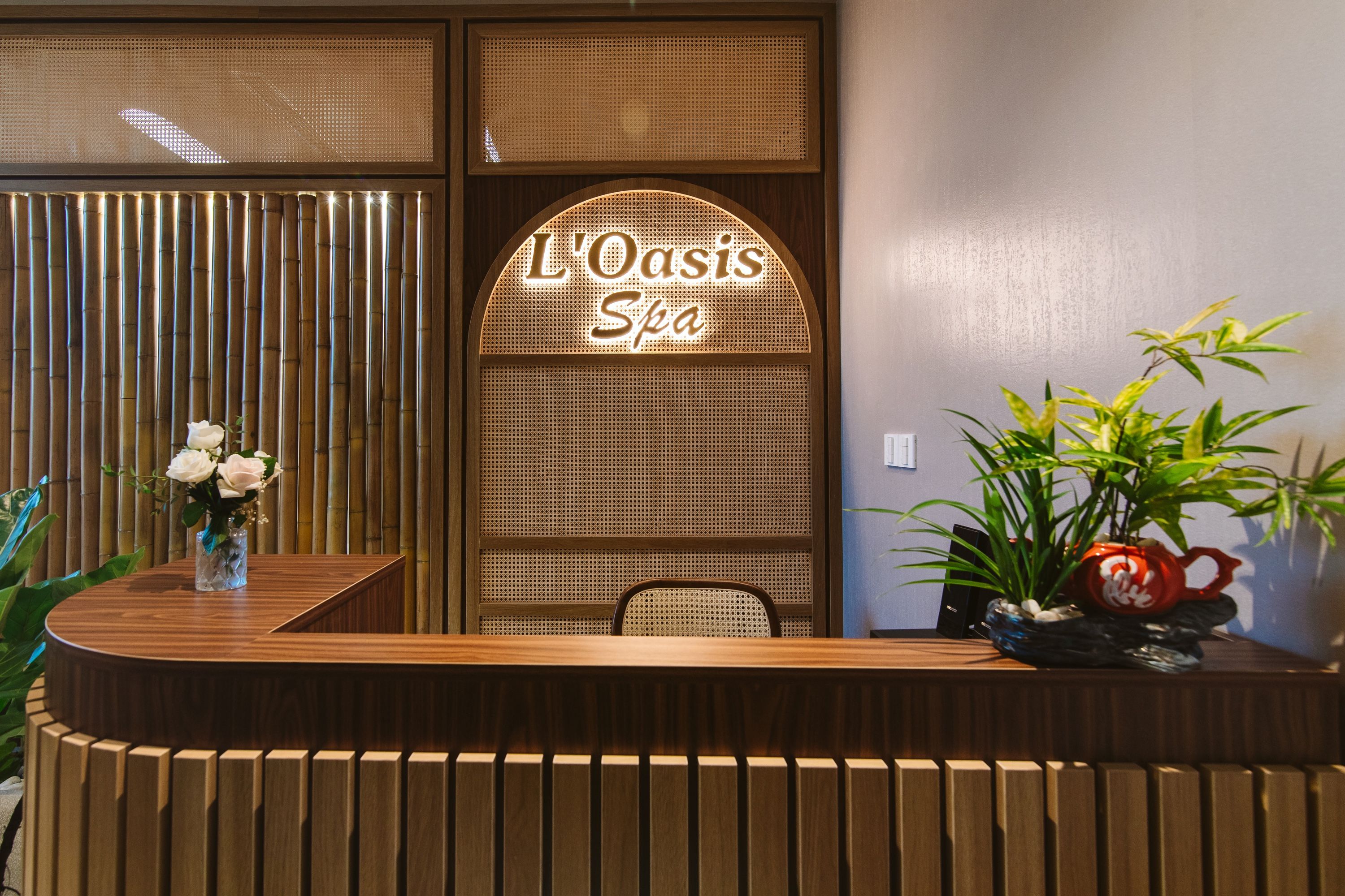 A reception desk with a sign reading 'L'Oasis Spa'.