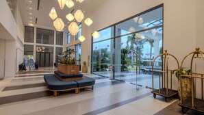A spacious lobby with a high ceiling, large windows, and modern lighting fixtures. - Le Palmier Ho Tram Resort (Ho Chi Minh City)