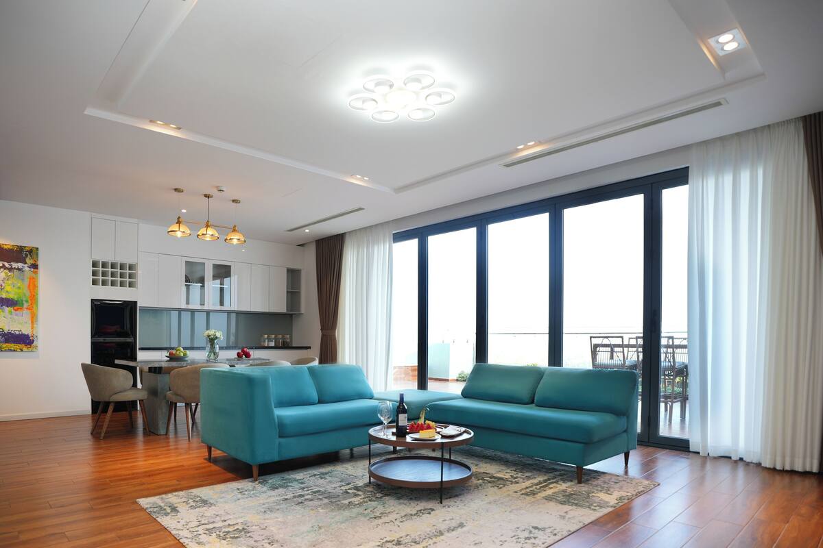A modern living room with a sofa, coffee table, and a view of the outside.