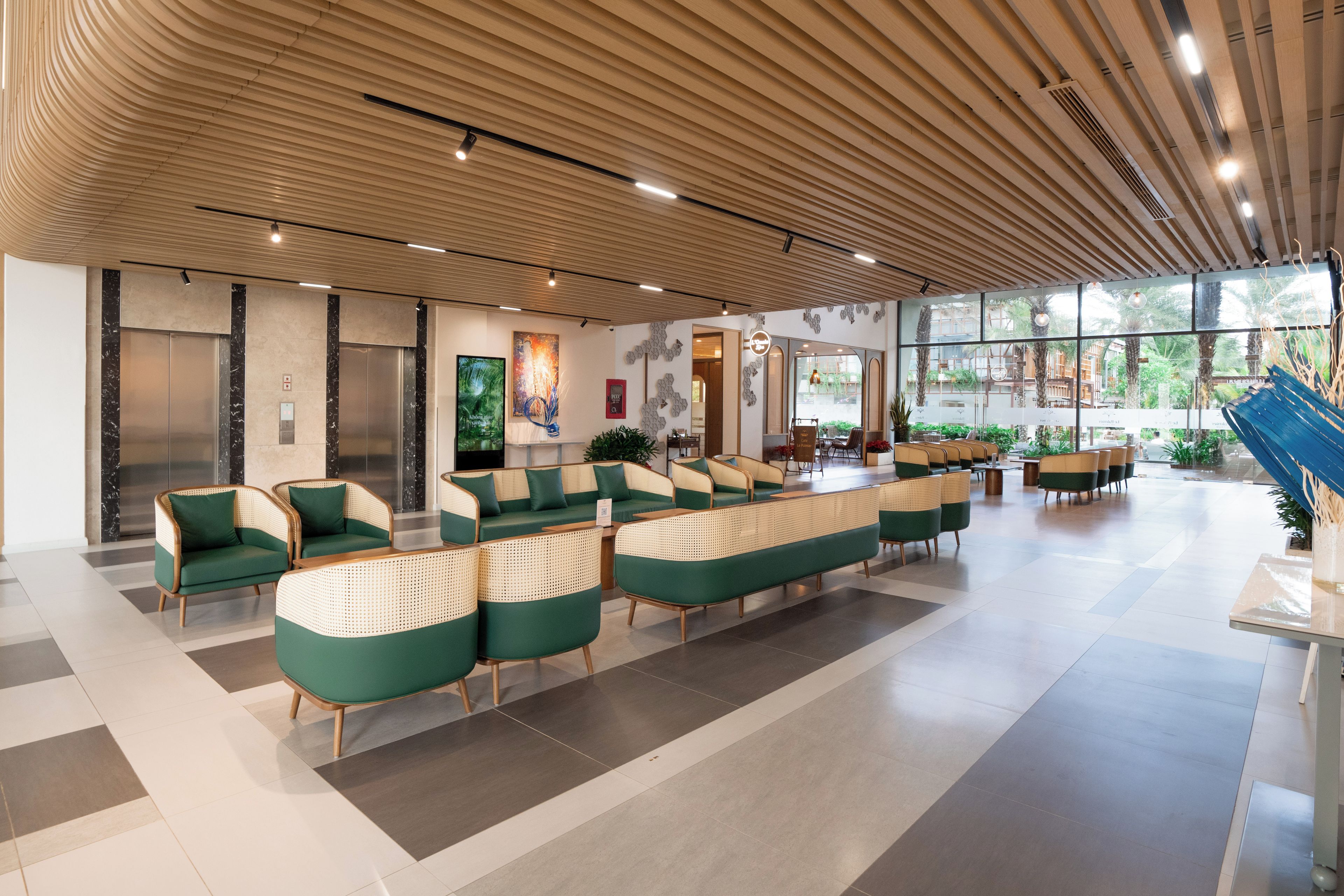 A modern lobby with a checkered floor, green and beige seating, and a wooden ceiling.