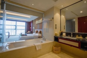Uma casa de banho moderna com um espelho grande, uma banheira e um lavatório.