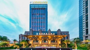 Un hôtel moderne doté d’une façade en verre remarquable et d’une entrée bien éclairée.