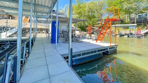 Une zone abritée avec un quai, une rampe pour bateaux, des sièges et une vue sur l’eau.
