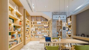 Una biblioteca moderna con estanterías de madera, una mesa central con sillas y una obra de arte grande en la pared.