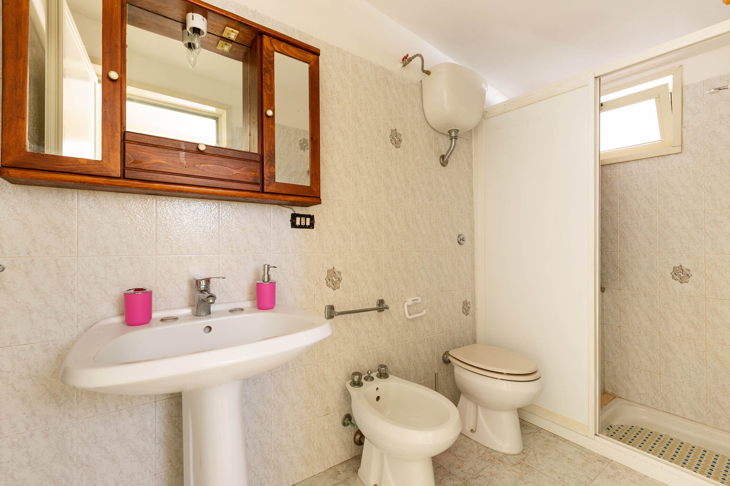 Une salle de bain équipée d’un lavabo, d’un bidet, de toilettes et d’un espace douche.