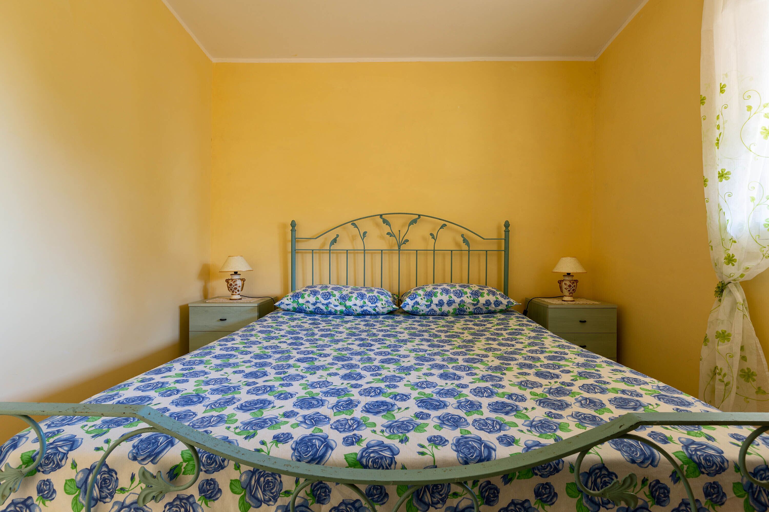 Un dormitorio con cama, dos mesitas de noche y una mesilla.