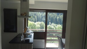 Une cuisine donnant sur une forêt, avec une porte-fenêtre coulissante.