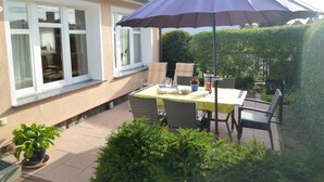 A patio with a table, chairs, and a purple umbrella.