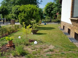 Un jardin bien entretenu, agrémenté de diverses plantes et d’un grand vase décoratif.