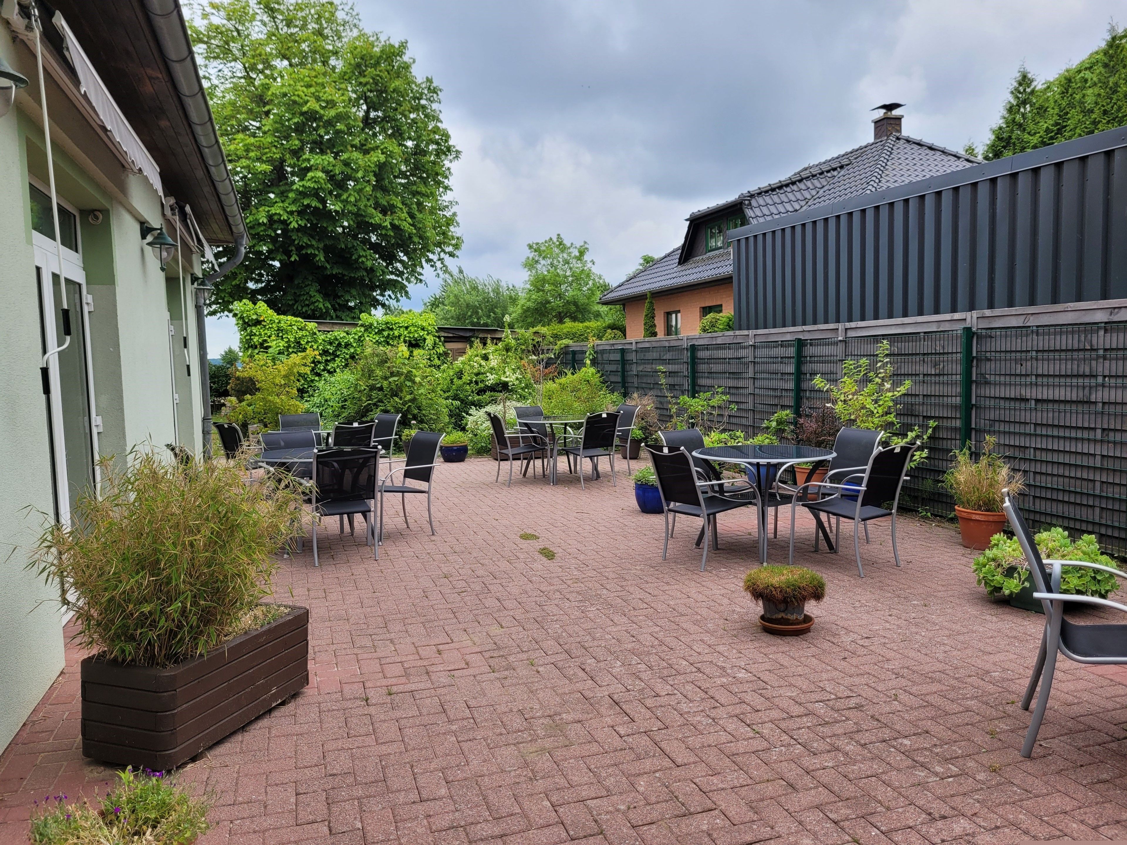 Un espace patio aménagé avec des meubles d’extérieur et des plantes en pot.