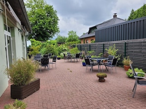 Un patio con mobiliario exterior y plantas en macetas.