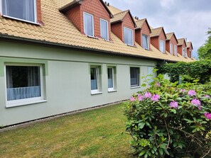 Una hilera de casas con muchas ventanas y un césped cuidado.