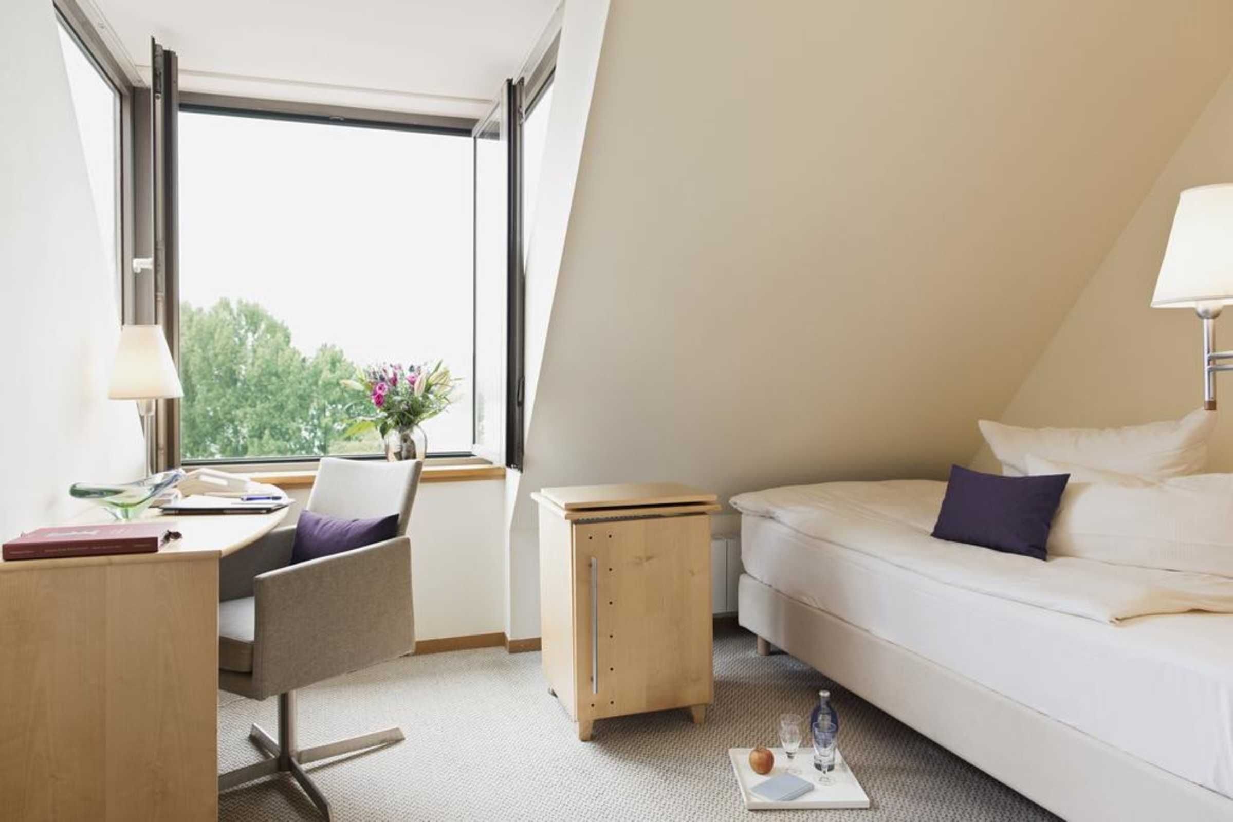 Una habitación de hotel moderna con escritorio, silla y cama.