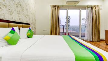 Habitación de hotel con cama, papel tapiz floral, vistas al exterior y una ventana con cortinas.