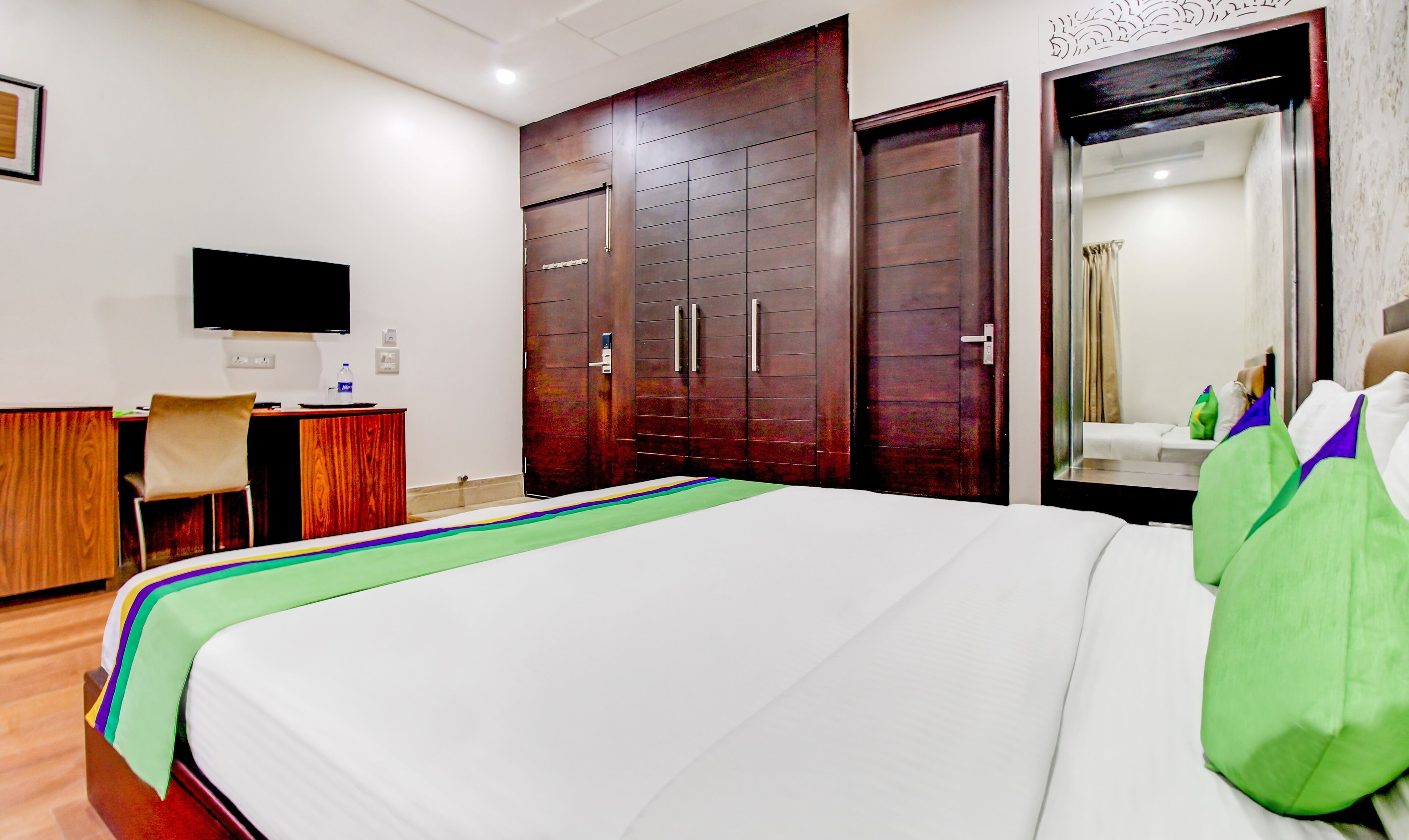 Een hotelkamer met een bed, een bureau, een stoel en een kledingkast.