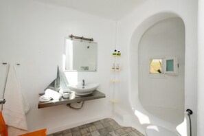 A bathroom with a white sink, mirror, and a shower area. - Mar Y Sol (Mykonos)