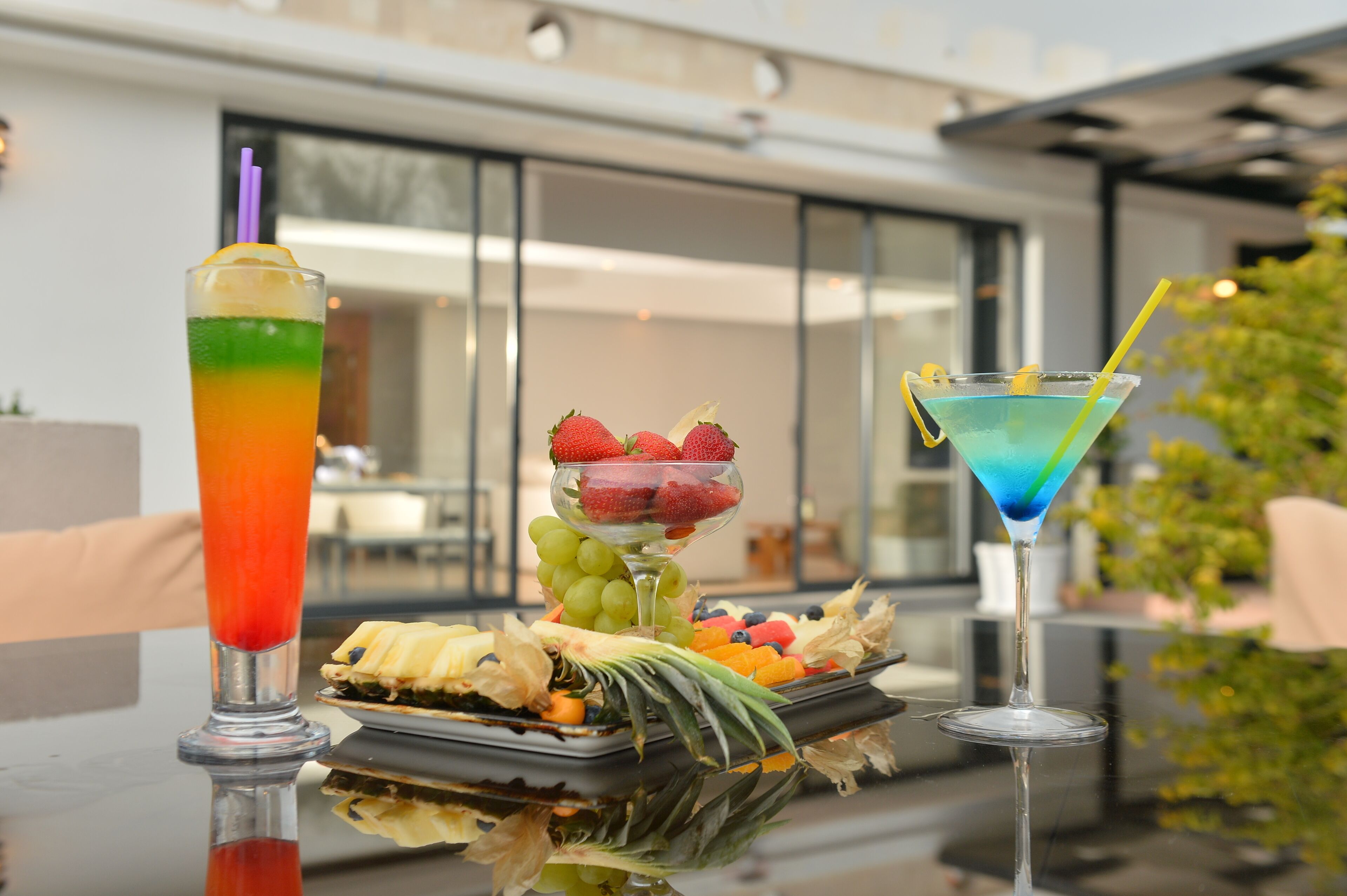 Una mesa con dos bebidas y una bandeja de fruta.