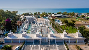 An aerial view of a resort with a large pool area, multiple buildings, and a view of the sea. - Miarosa Kemer Beach (Kemer)