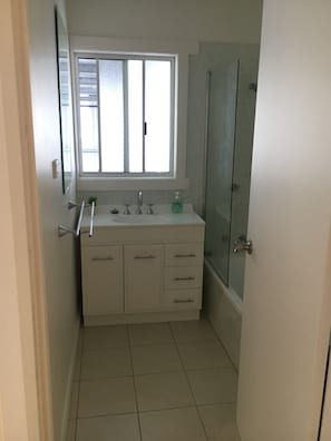 Een bad/douchecombinatie, zeep, toiletpapier