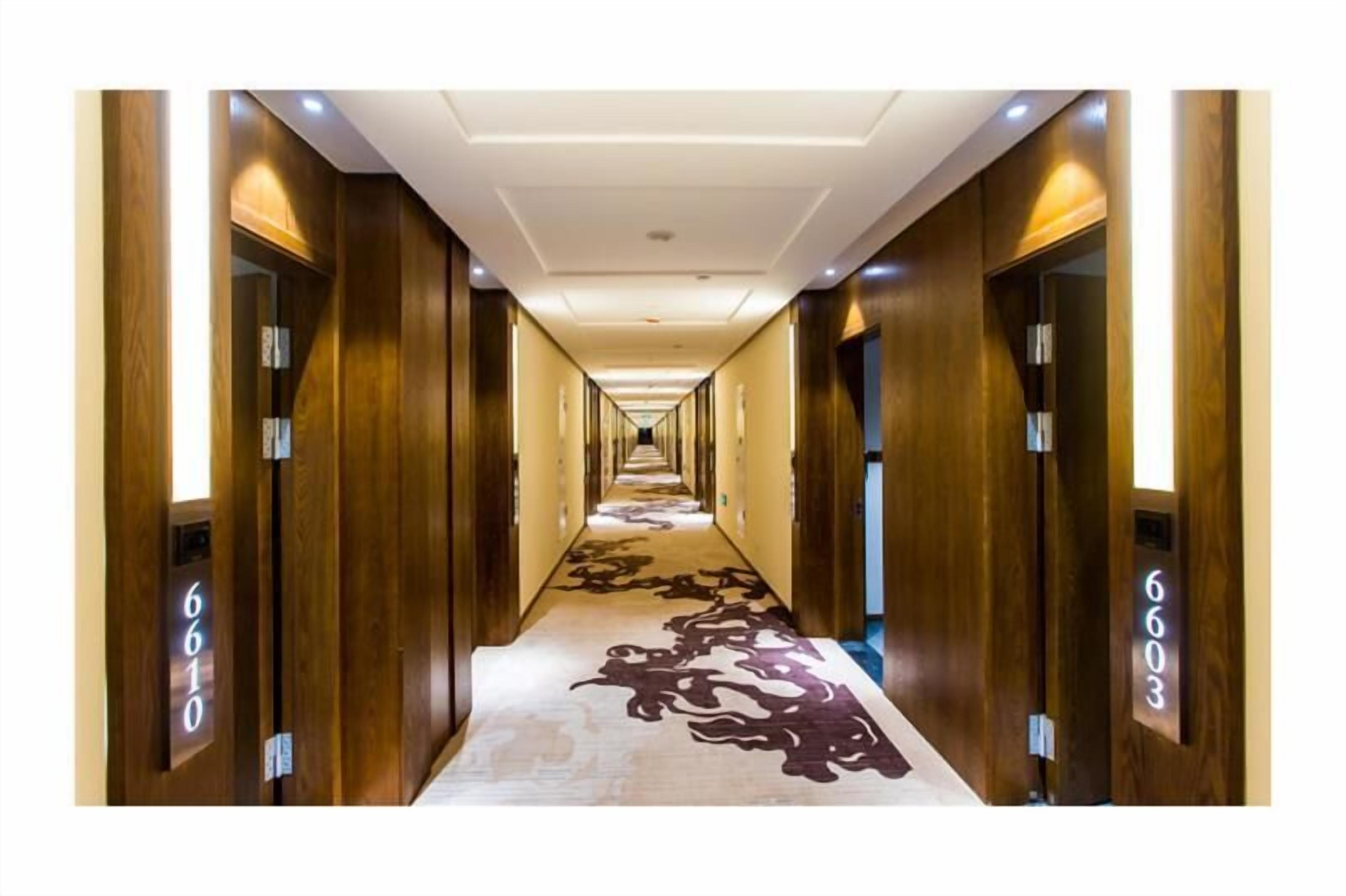 A long, narrow hallway with wooden walls and doors, each marked with a number.