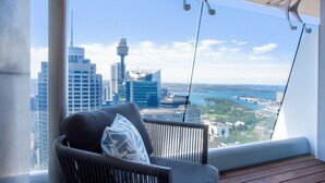 A balcony with a view of a cityscape, including a tower and a body of water. - Prestige City Chic I90 (Sydney)