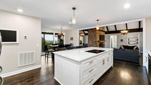 A spacious kitchen with a large island, a dining area with a table and chairs, and a living area with a sofa. - Cabin on the Hill - North Nashville Stunner! (Hendersonville)