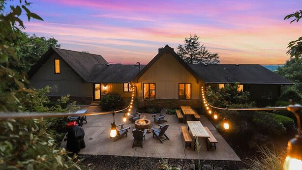 A two-story building with a patio area featuring outdoor seating and a fire pit. - Cabin on the Hill - North Nashville Stunner! (Hendersonville)