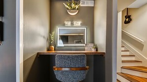A small, modern bathroom with a vanity, mirror, and a stool. - Walk to Broadway - Heart of downtown (Nashville)