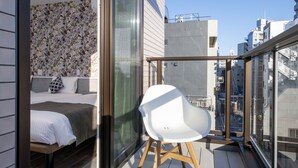 A modern balcony with a bed, a white chair, and a purple pouf. - Hotel SAILS Asakusa (Tokyo)