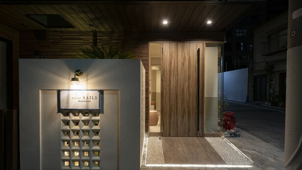 A modern hotel entrance with a wooden facade, a lighted sign, and a stone pathway leading to the door. - Hotel SAILS Asakusa (Tokyo)