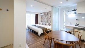 A modern hotel room with a wooden dining table, two single beds, a kitchenette, and a large window. - Hotel SAILS Asakusa (Tokyo)