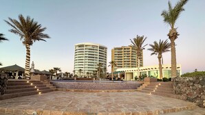 A resort with a central courtyard, palm trees, and high-rise buildings.