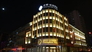 Un hôtel doté d’une enseigne bien visible indiquant « Hôtel Chonpines » et présentant une conception architecturale circulaire.