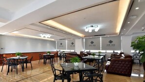 A modern hotel lobby with multiple seating areas, including tables and sofas, and a polished wooden floor. - Chonpines Hotel (Zhanjiang)