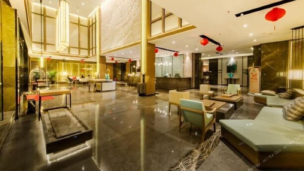 Un hall espacioso con techo alto, mobiliario moderno y faroles decorativos rojos.