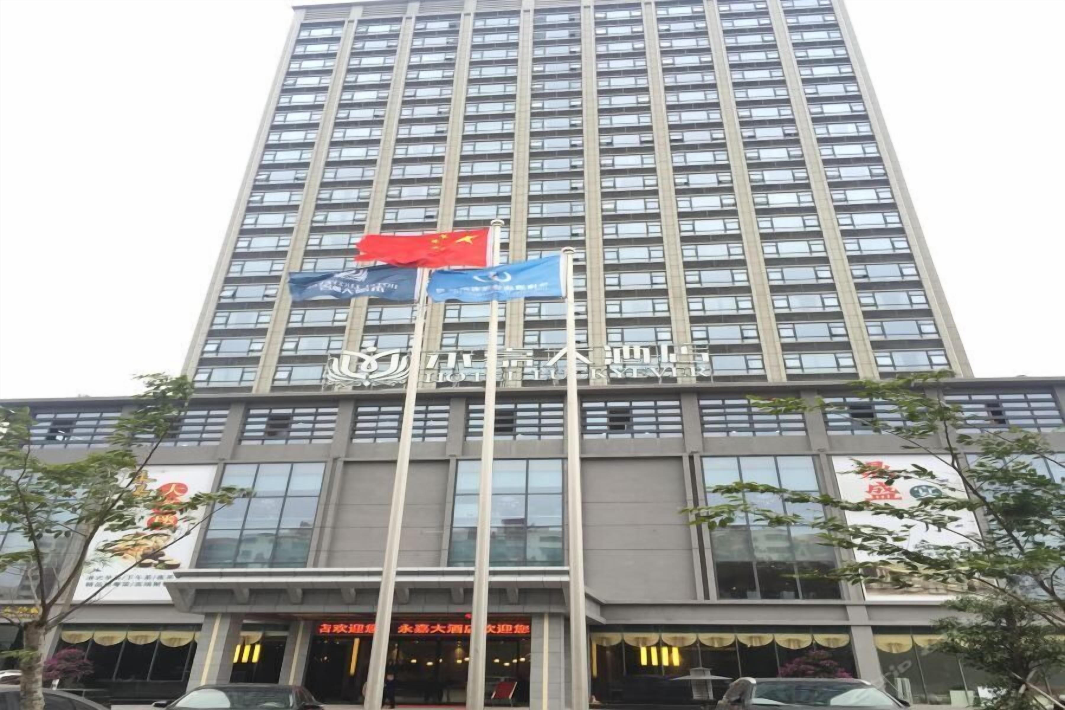 Un edificio de hotel alto con varias banderas, incluyendo una roja y una azul.