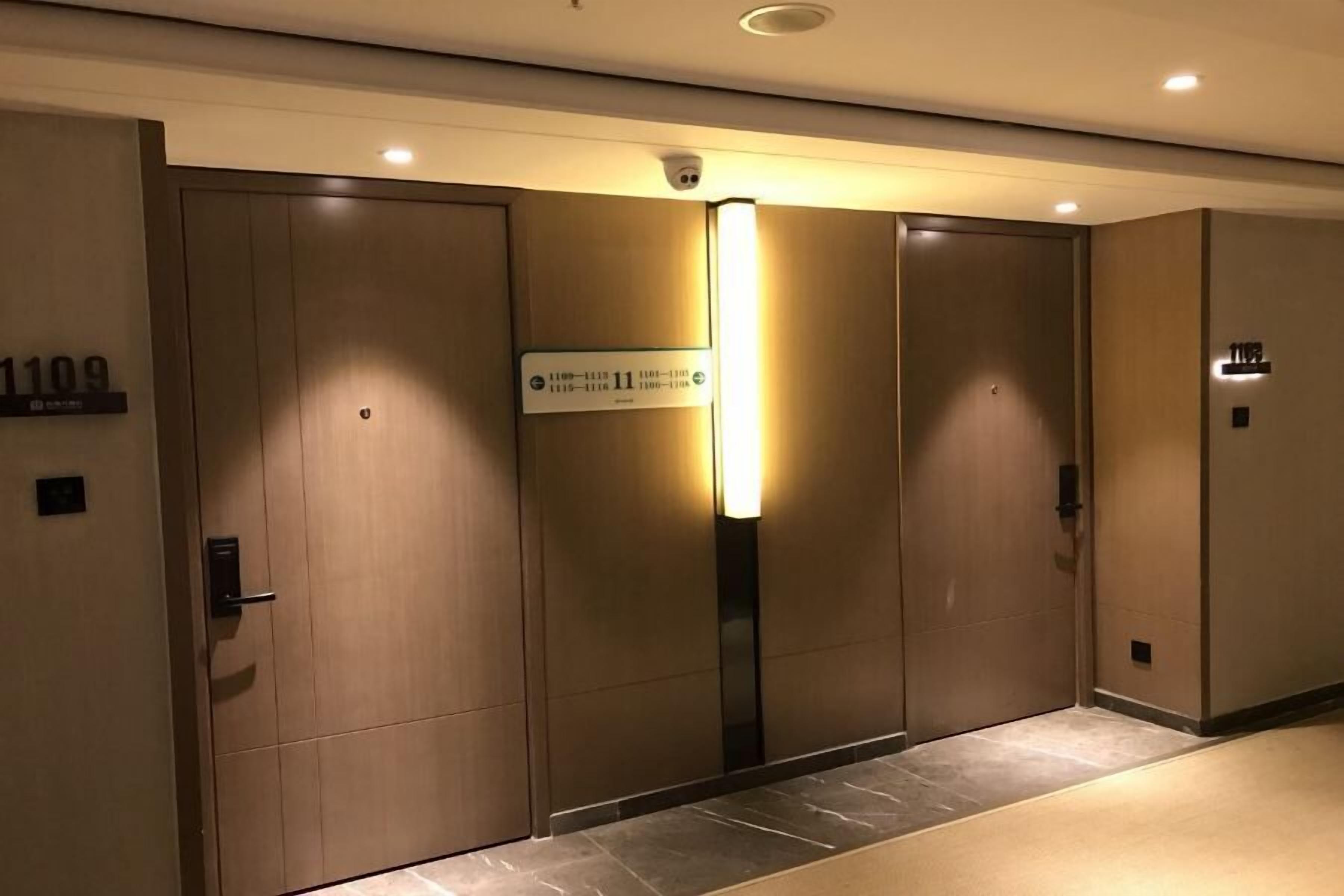 Un ascensore moderno con un display digitale e una telecamera di sicurezza sopra.
