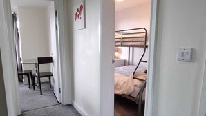 A hallway leading to a bedroom with bunk beds, a desk, and a chair. - Beachside Home - Sleeps 5, Garden, Parking & Pets (Skegness)