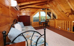 Relax in this serene retreat with a single bed, patterned quilt, and wooden wardrobe.