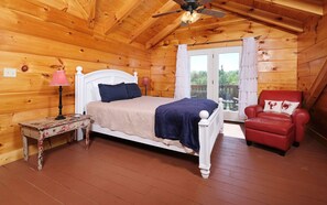 Relax in this serene bedroom with a single bed, a small table, and a comfortable armchair.