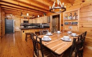 Cozy cabin-style accommodation with a dining area for four, kitchenette, and bookshelf.