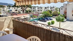 Un balcon donnant sur un parking et des immeubles.