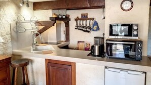Une cuisine compacte équipée d’un évier, d’un four à micro-ondes, d’un grille-pain et d’un réfrigérateur.