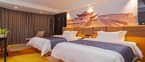 Habitación de hotel con dos camas, un mural grande de un edificio tradicional, un escritorio con una planta y una silla.