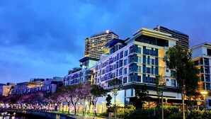 Un hotel moderno con varios pisos, amplias ventanas y una fachada bien iluminada.