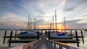 Un puerto deportivo con barcos amarrados a muelles de madera al atardecer.