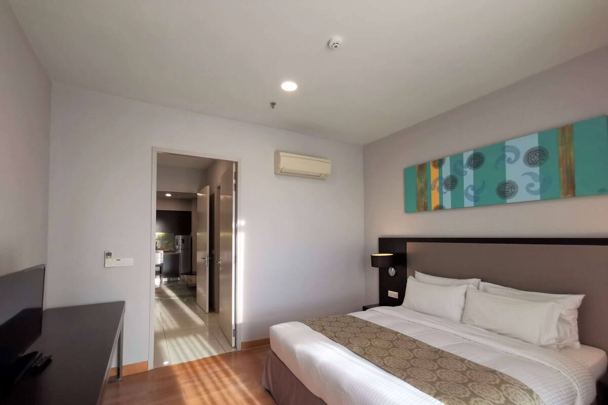 Una habitación de hotel con una cama, un escritorio y vistas a la cocina.