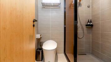 Un baño moderno con inodoro, ducha y secador de manos.