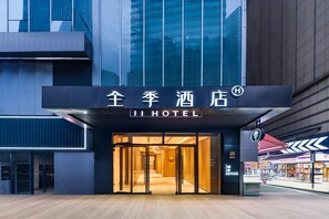 A hotel entrance with a modern design, featuring a glass facade and a sign with Chinese characters. - Ji Hotel (Chongqing)
